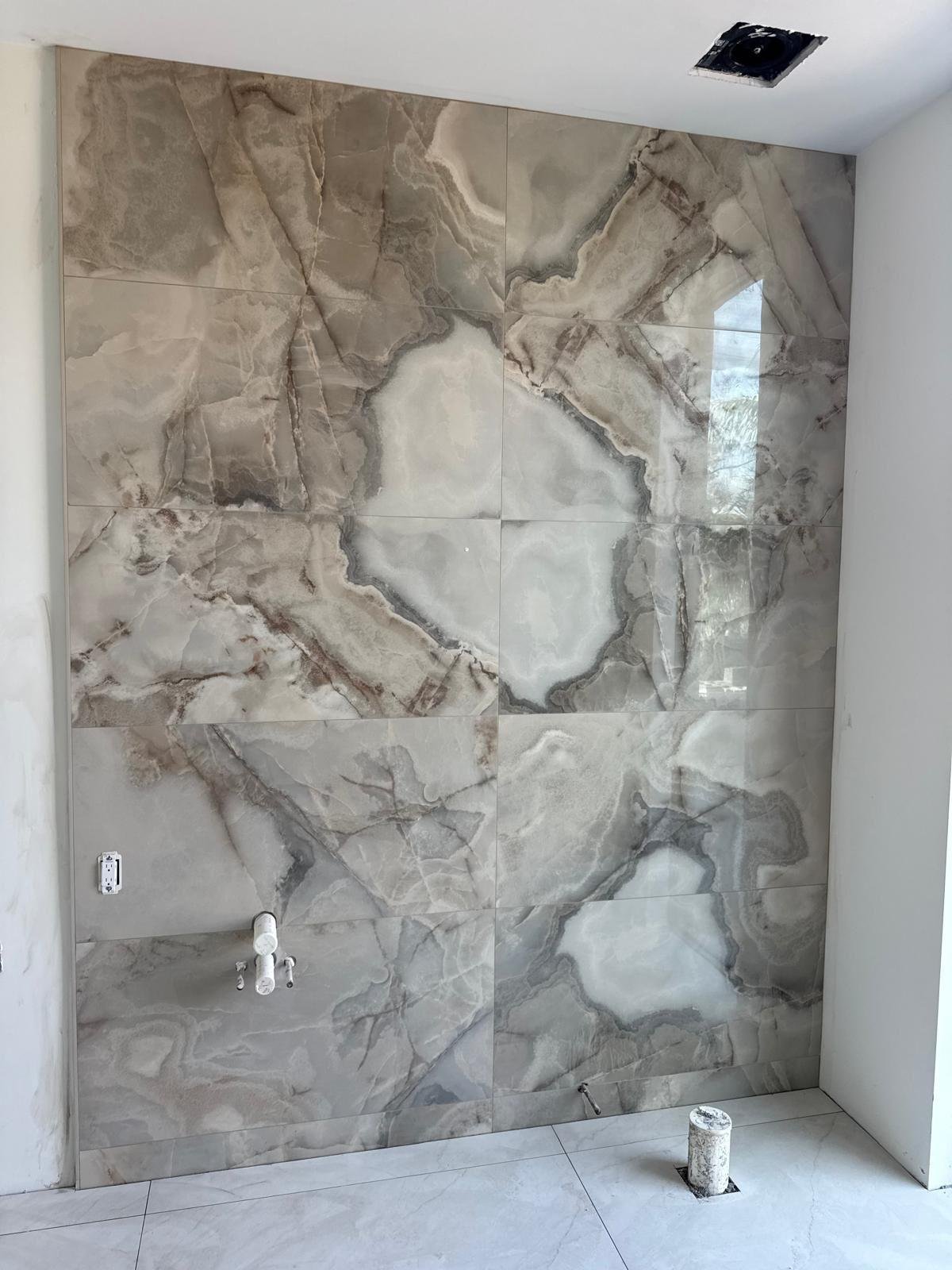 Book-matched natural stone shower wall with mirrored veining