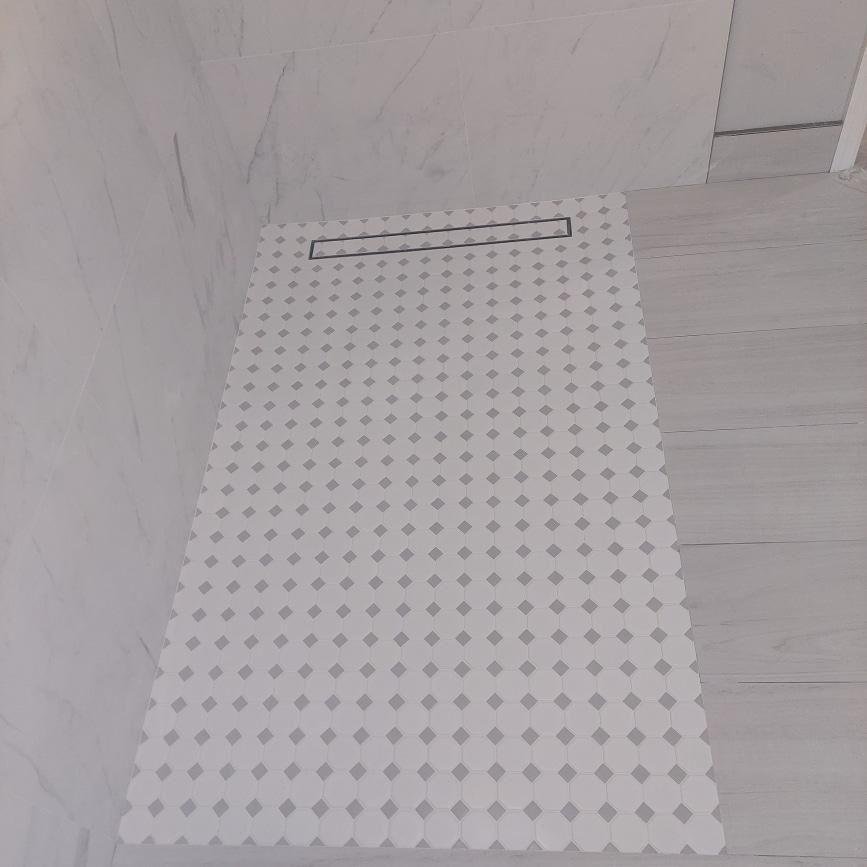 Curbless shower floor with a linear drain and mosaic tile