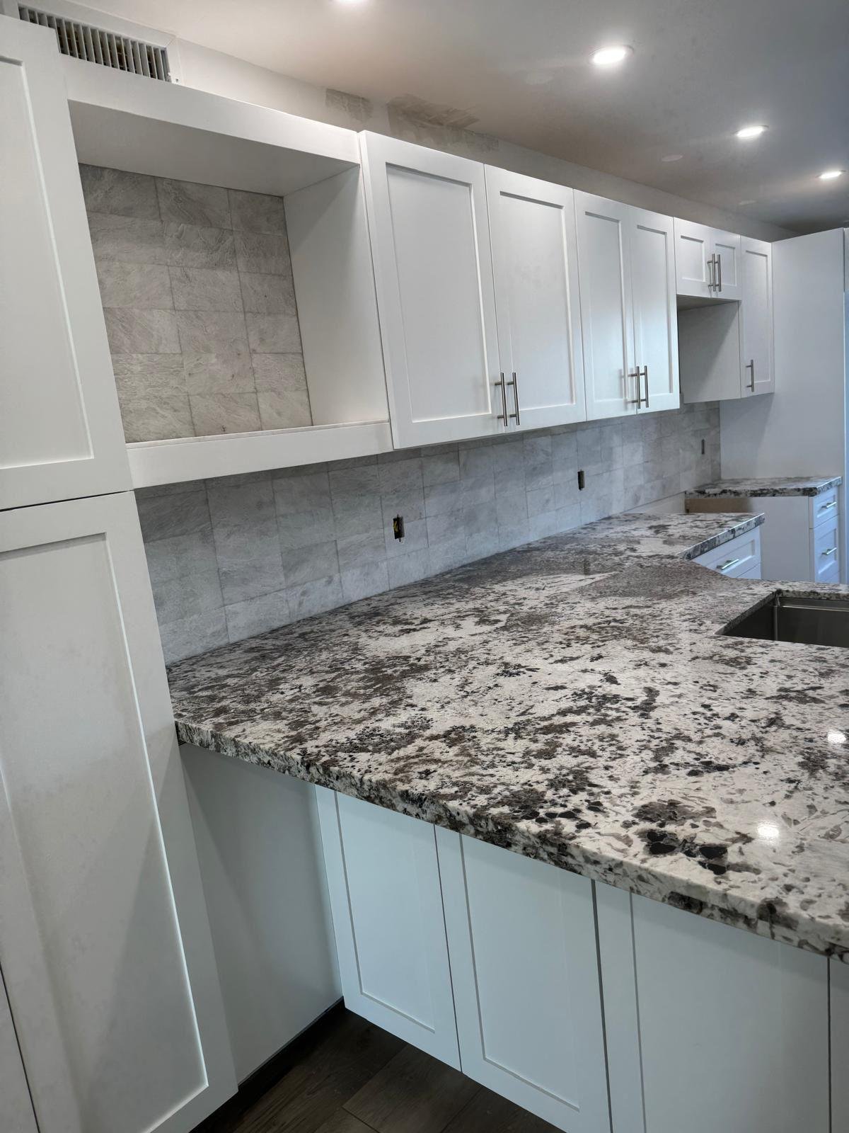 Kitchen backsplash installed above a granite countertop