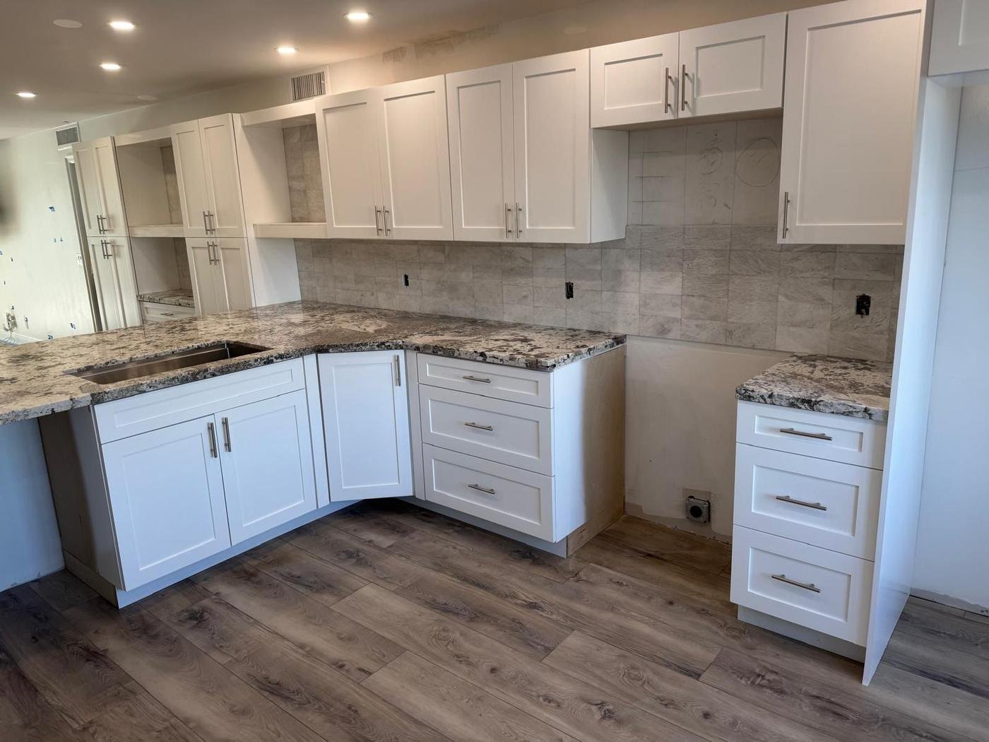 Kitchen backsplash with white cabinets and granite countertops
