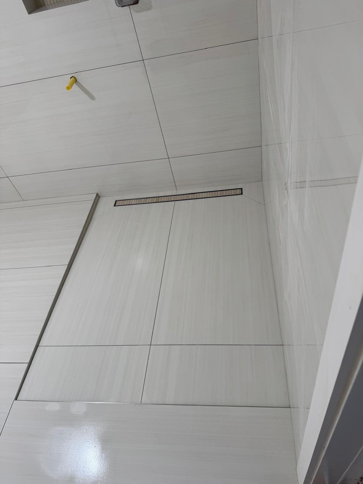 Linear drain set into a large-format porcelain shower floor