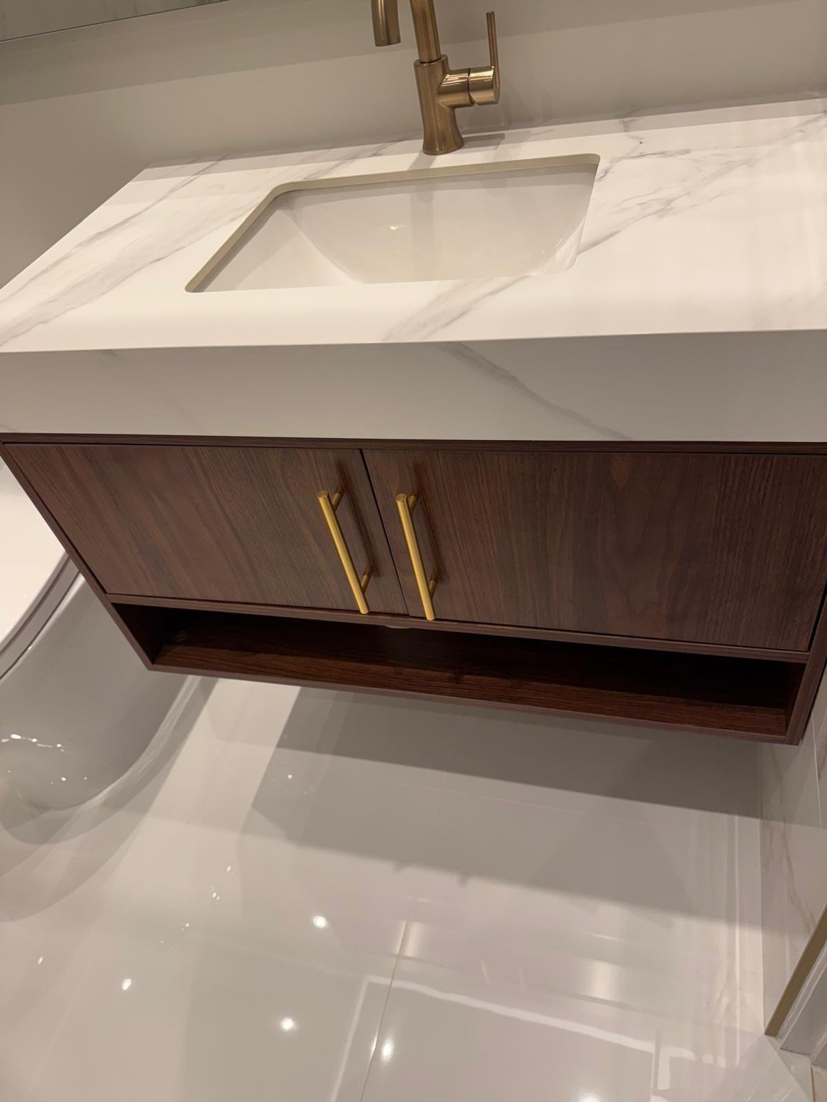 Marble vanity countertop with an undermount sink and brushed gold faucet