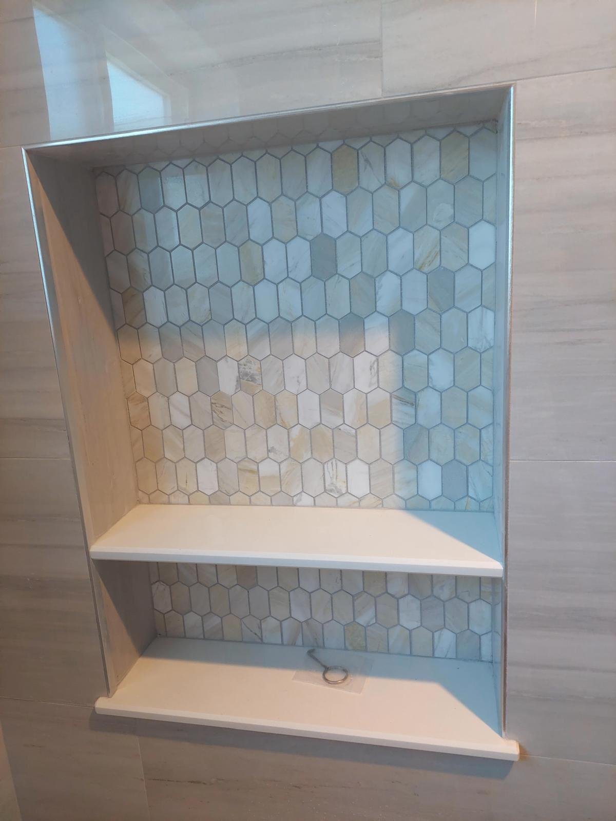 Mosaic tile accent inside a recessed shower niche